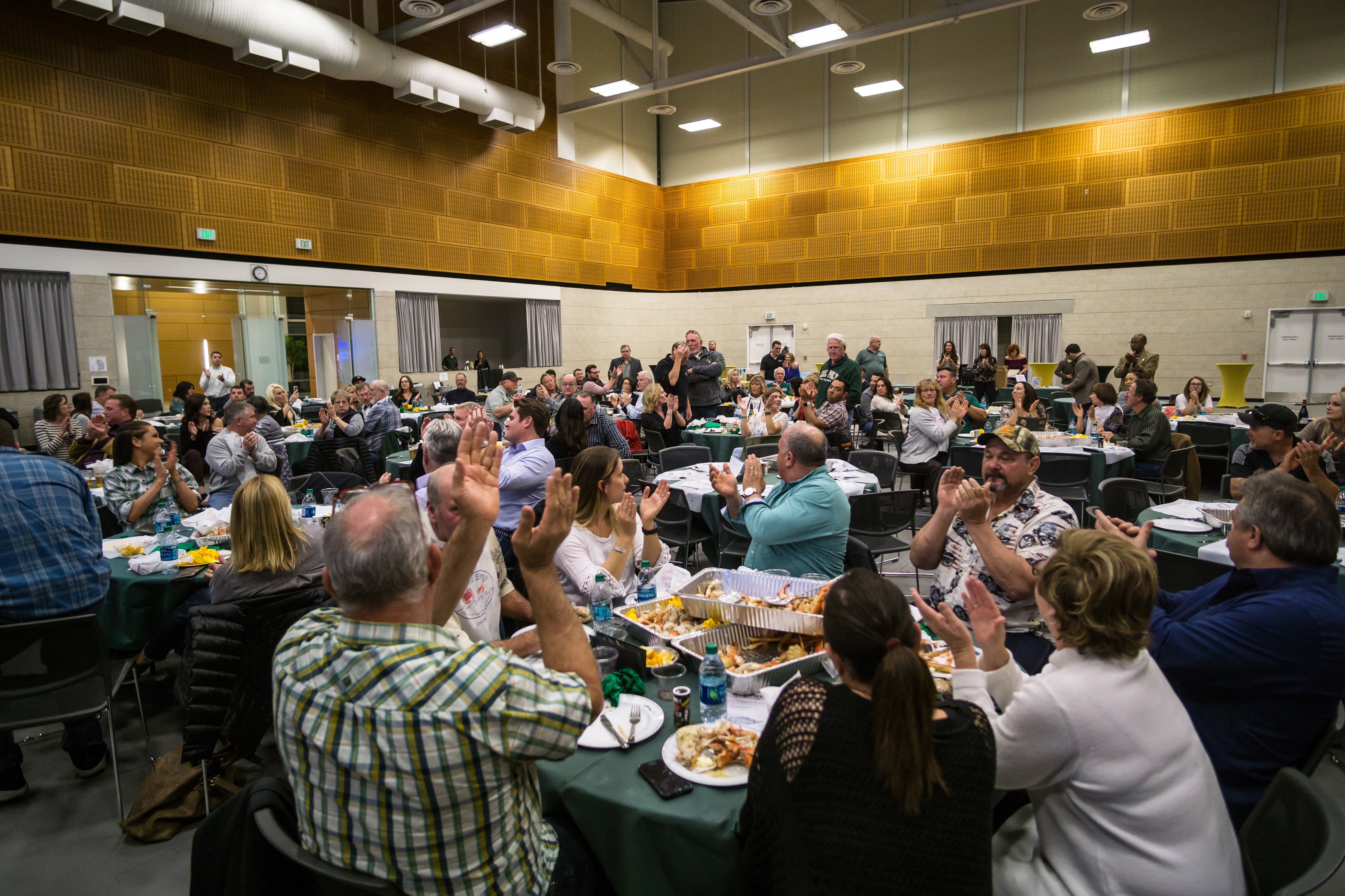 Alumni and supporters applauding at the Cal Poly Wrestling dinner benefit