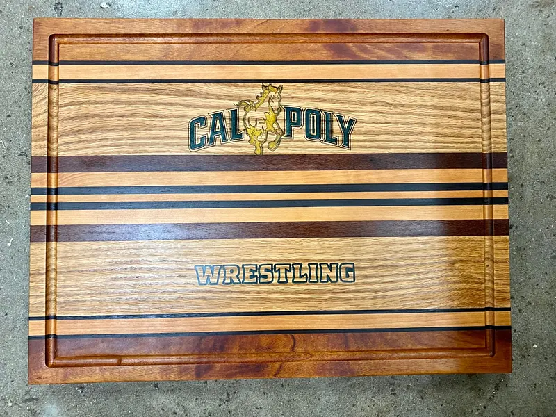 Last year's Cal Poly Wrestling butcher block: striped hardwood with the Cal Poly and Wrestling logos