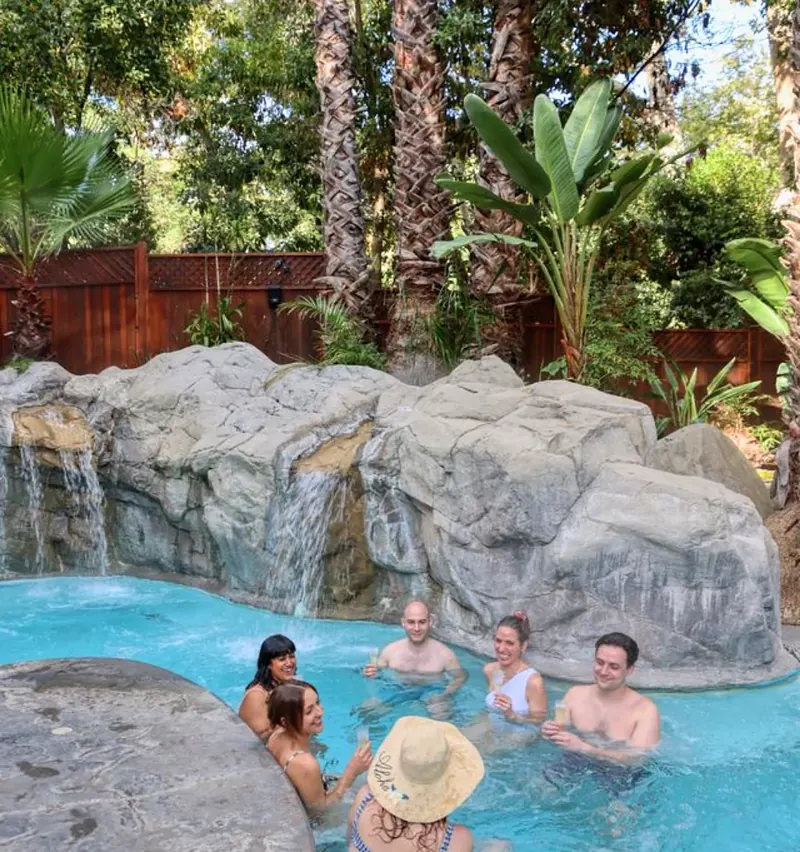 Guests in the rock waterfall pool at Sycamore Mineral Springs Resort & Spa